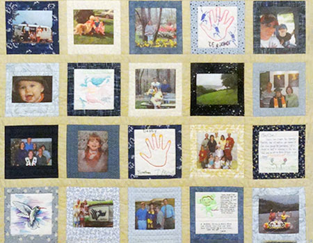 Several quilt squares of family photos and children's drawings on a yellow-tan backing.