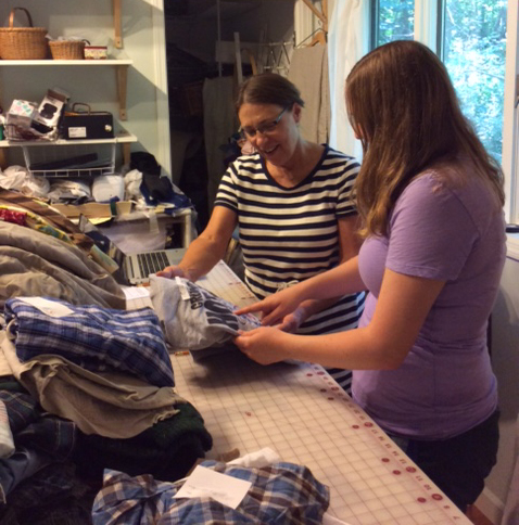 Jan Bjorkman sorts through t-shirts with a client to pick out which ones to use in the quilt.