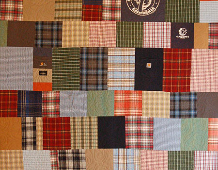 Cropped view of the Musinsky memorial quilt in outdoorsy tones.